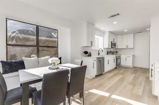 a living room with stainless steel appliances kitchen island granite countertop a stove a table and chairs