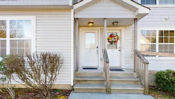 a front view of a house with a tree