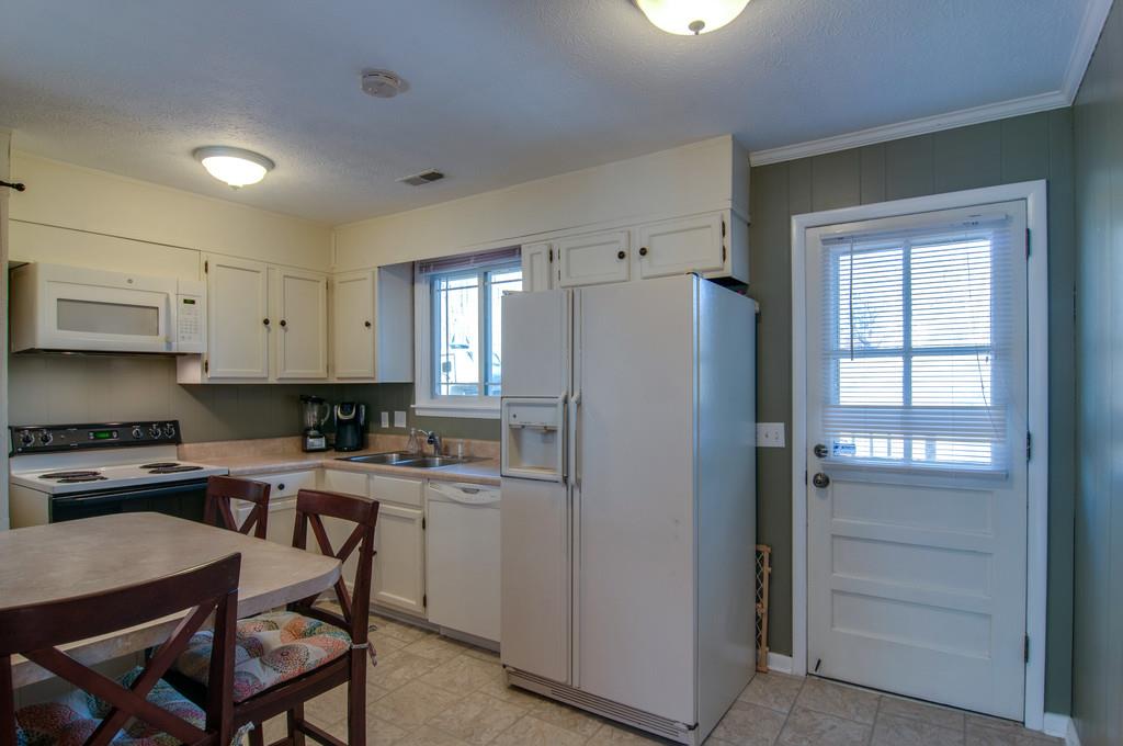 7709 Chester Road Fairview, TN 37062 - Photo 15 of 29 a kitchen with a refrigerator a stove and chairs