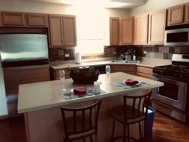 1502 Remington Lane Round Lake, IL 60073 - Photo 11 of 29 a kitchen with a stove a sink and a microwave