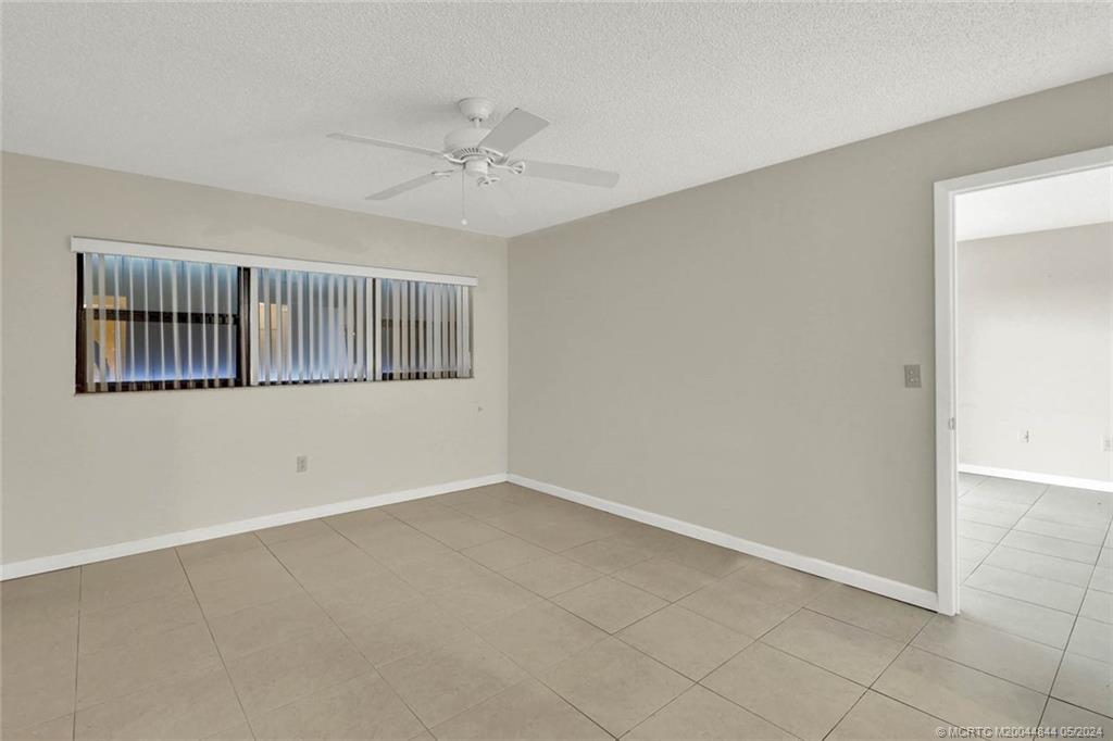 7400 South Ocean Drive, Unit 102 Jensen Beach, FL 34957 - Photo 14 of 26 an empty room with windows and fan