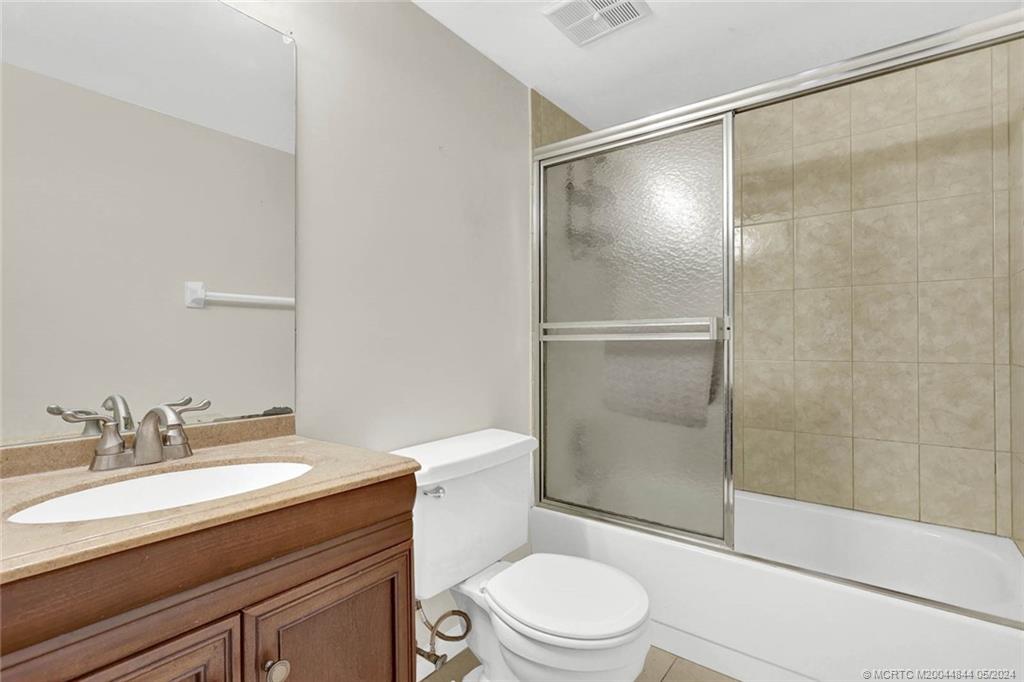 7400 South Ocean Drive, Unit 102 Jensen Beach, FL 34957 - Photo 23 of 26 a bathroom with a granite countertop sink toilet and shower