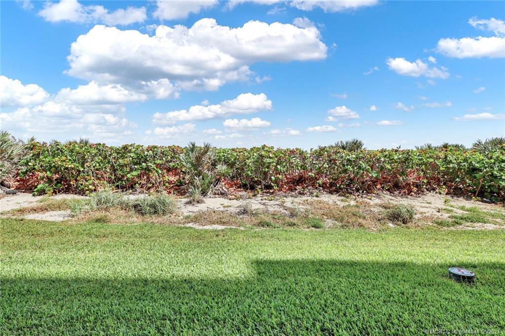 7400 South Ocean Drive, Unit 102 Jensen Beach, FL 34957 - Photo 4 of 26 a view of a pathway both side of grassy field with shrub