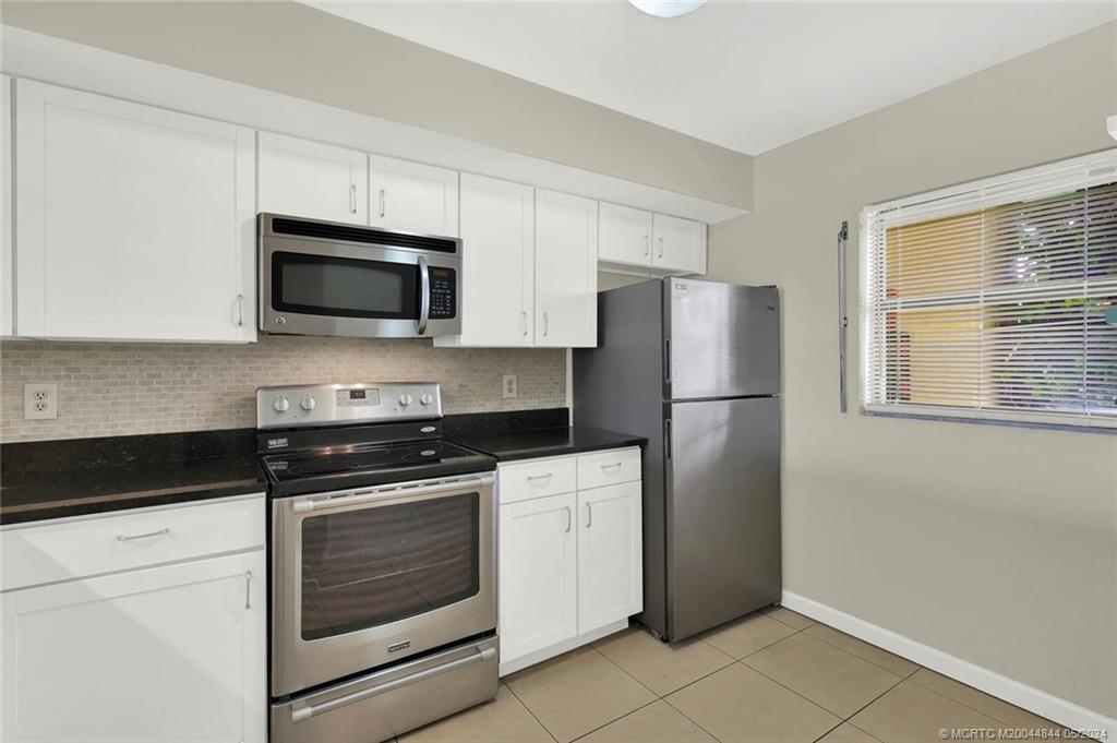 7400 South Ocean Drive, Unit 102 Jensen Beach, FL 34957 - Photo 7 of 26 a kitchen with a refrigerator stove and microwave