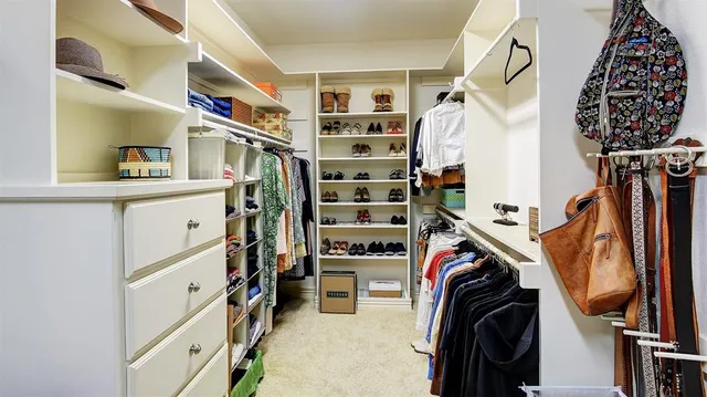 a view of walk in closet with clothes and shoes
