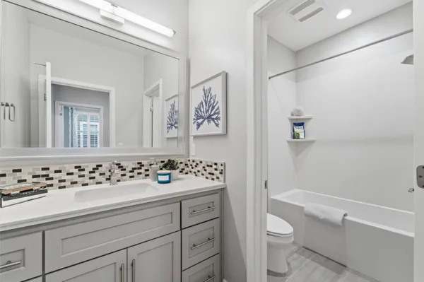 a bathroom with a sink mirror vanity and toilet