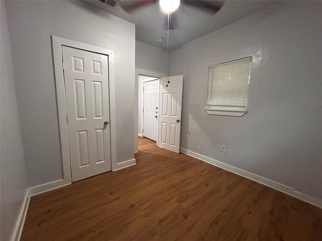 3615 Meadow Street Dallas, TX 75215 - Photo 12 of 15 Unfurnished bedroom featuring dark wood-style floors, ceiling fan, and a closet