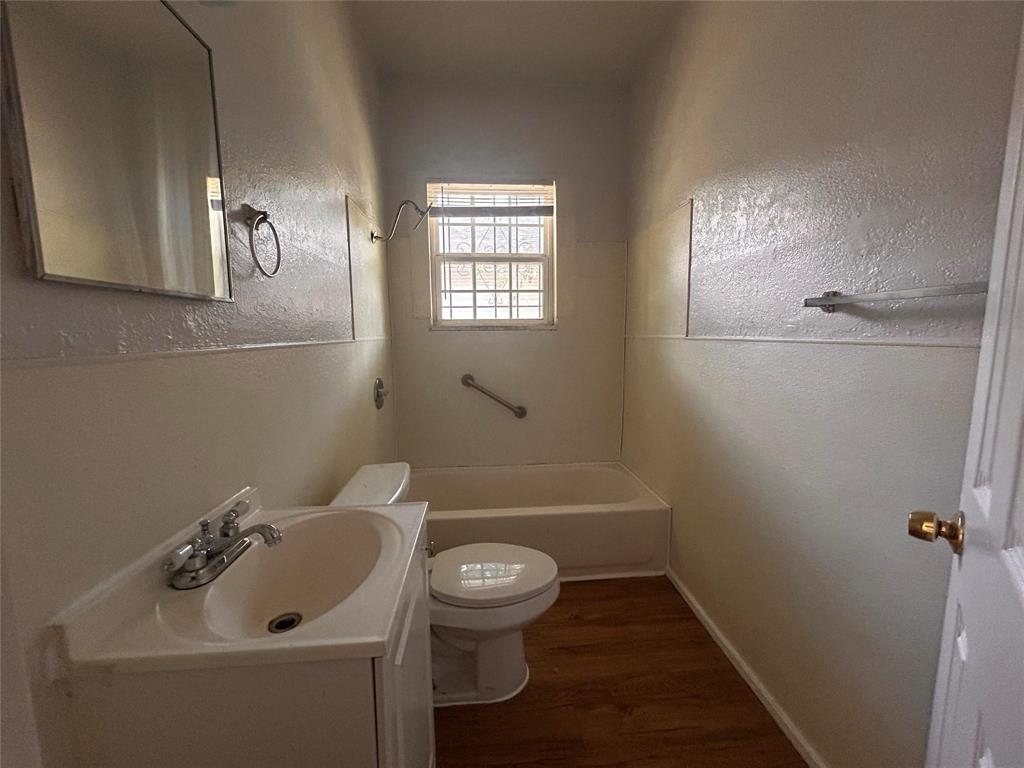 3615 Meadow Street Dallas, TX 75215 - Photo 14 of 15 Full bath featuring vanity, dark wood finished floors, a textured wall, and shower combination