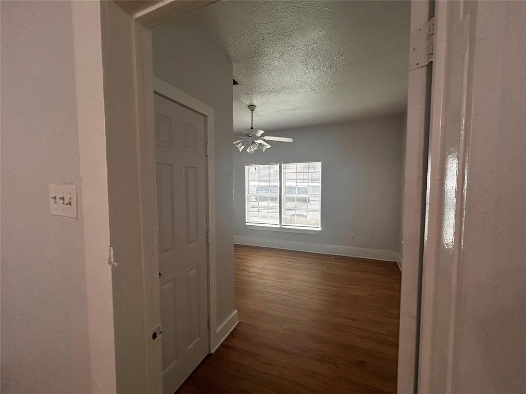 3615 Meadow Street Dallas, TX 75215 - Photo 5 of 15 Hall featuring a textured ceiling and dark wood-style floors