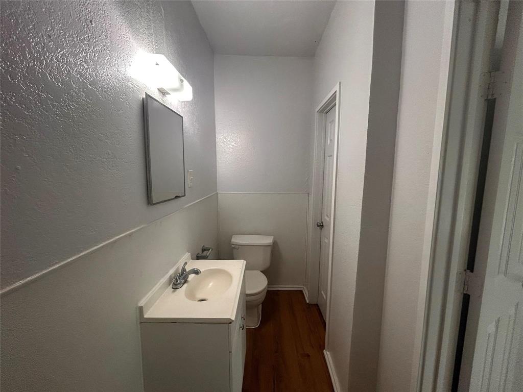 3615 Meadow Street Dallas, TX 75215 - Photo 8 of 15 Bathroom with a textured wall, vanity, and dark wood-type flooring