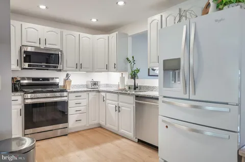 a kitchen with cabinets stainless steel appliances and a counter space