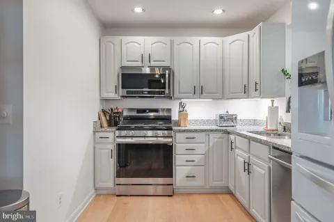 a kitchen with white cabinets stainless steel appliances and sink