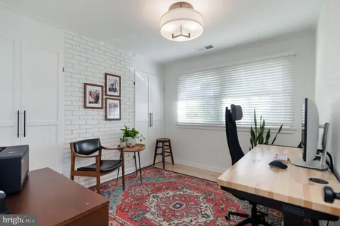 a view of a workspace with furniture and a window