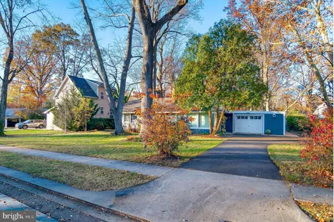 a view of a house with big yard and large trees