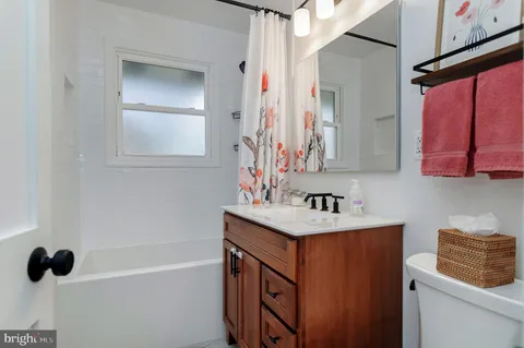 a bathroom with a sink vanity tub and a mirror