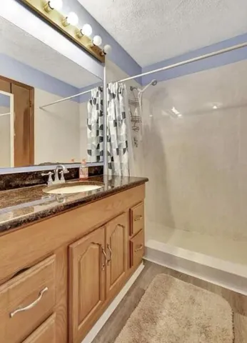 a bathroom with a sink a mirror and a shower