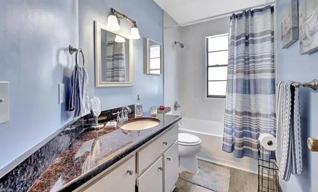 a bathroom with a double vanity sink toilet and shower