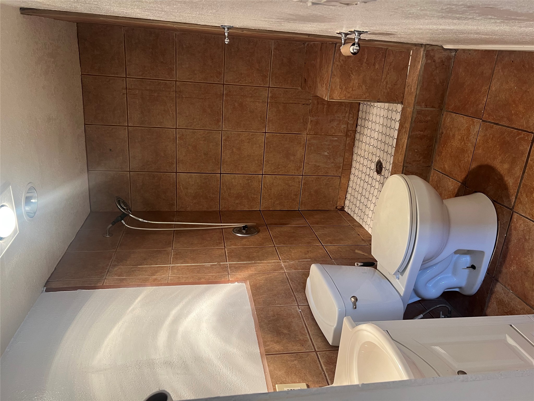 6405 Torres Street Austin, TX 78741 - Photo 4 of 14 A compact bathroom featuring a tiled walk-in shower and integrated bench seating.
