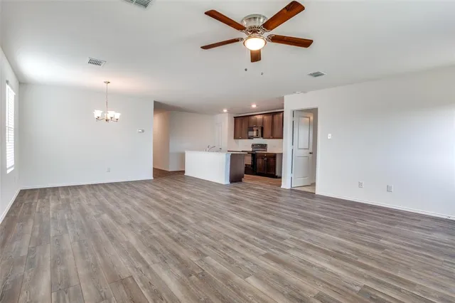 a view of a kitchen with a dishwasher a kitchen island hardwood floor and a ceiling fan