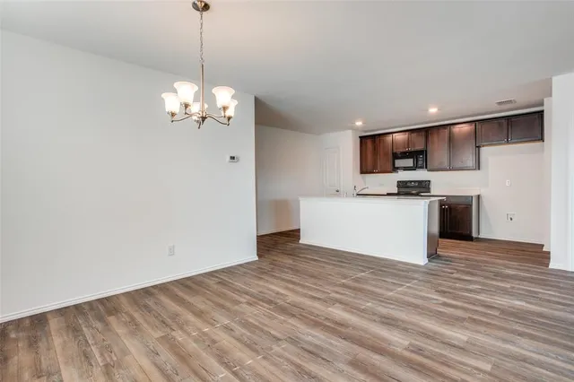 a view of a kitchen with a sink a microwave and cabinets