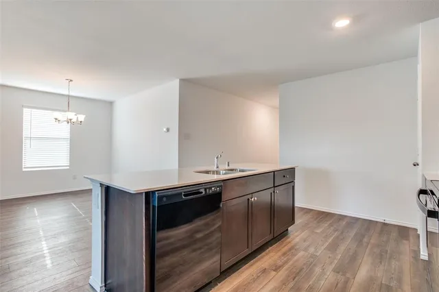 a kitchen with stainless steel appliances granite countertop a sink and wooden floor