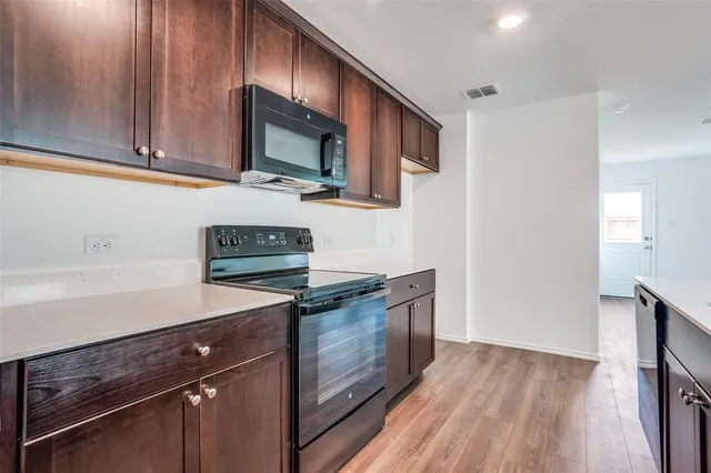 a kitchen with stainless steel appliances granite countertop a stove a sink and a microwave