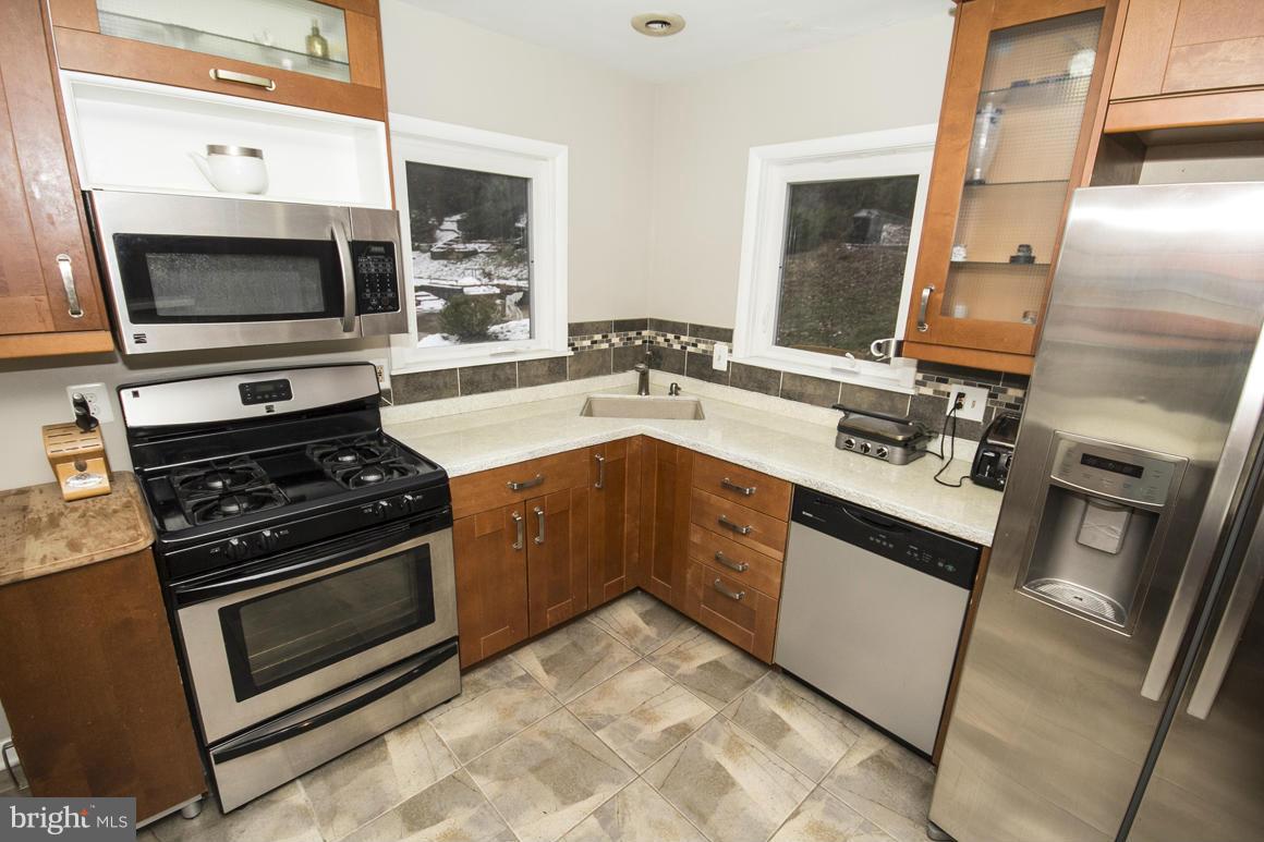 8216 Edwill Avenue Rosedale, MD 21237 - Photo 11 of 27 a kitchen with stainless steel appliances granite countertop a stove microwave and sink