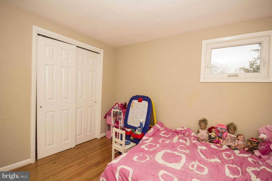 8216 Edwill Avenue Rosedale, MD 21237 - Photo 17 of 27 a bedroom with a bed a dresser and wooden floor
