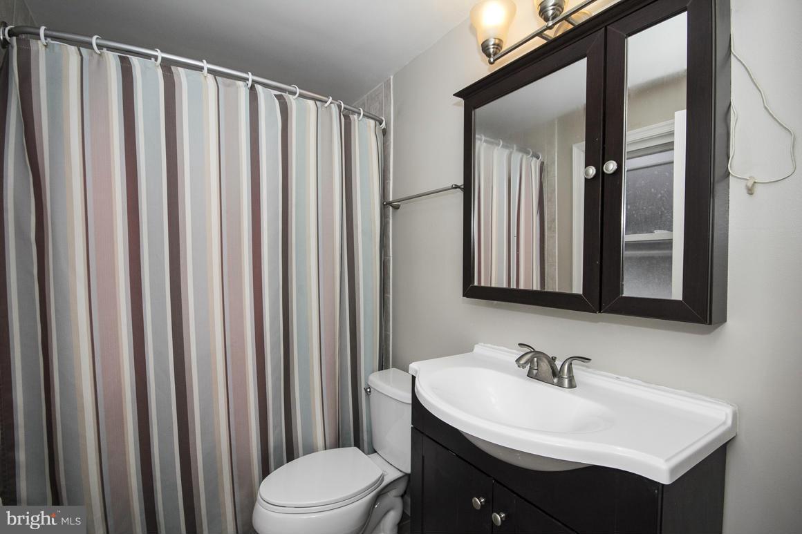 8216 Edwill Avenue Rosedale, MD 21237 - Photo 20 of 27 a bathroom with a sink a toilet and mirror