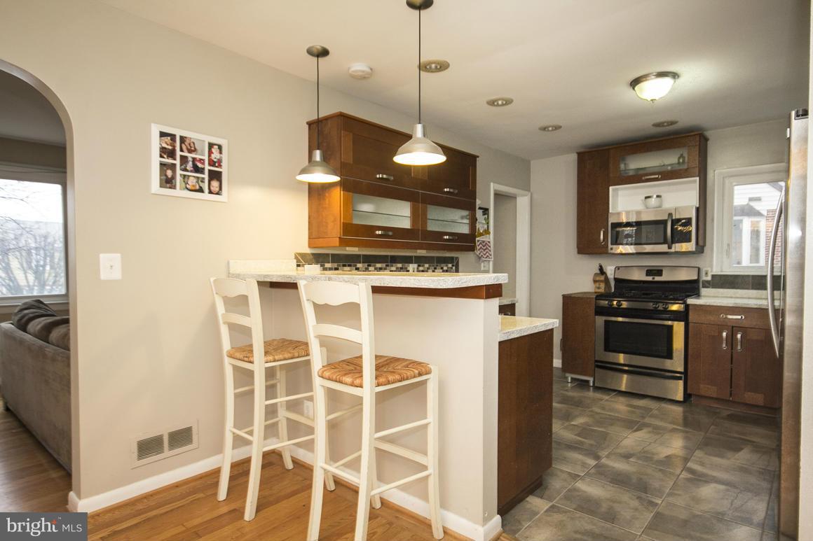8216 Edwill Avenue Rosedale, MD 21237 - Photo 9 of 27 a kitchen with a stove kitchen island and stainless steel appliances