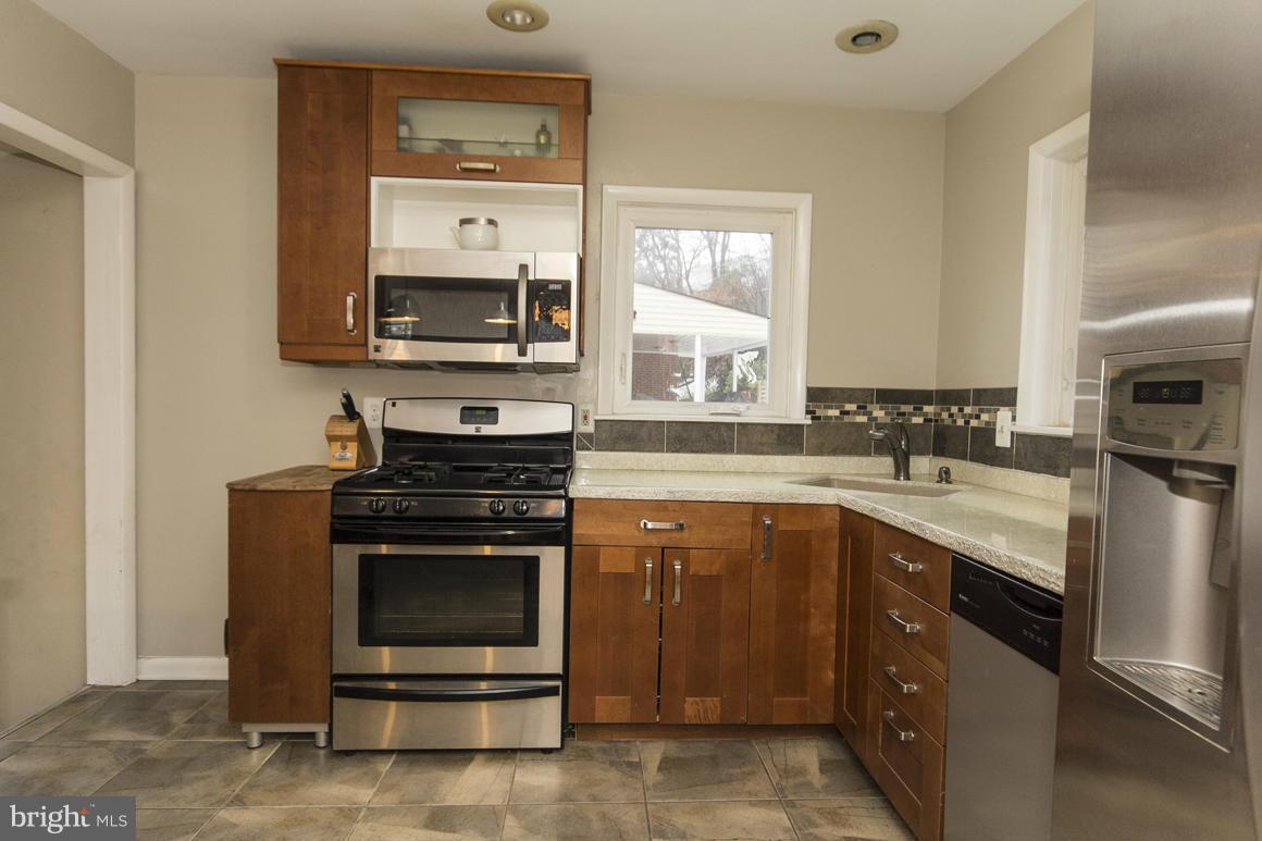 8216 Edwill Avenue Rosedale, MD 21237 - Photo 10 of 27 a kitchen with a stove and a microwave