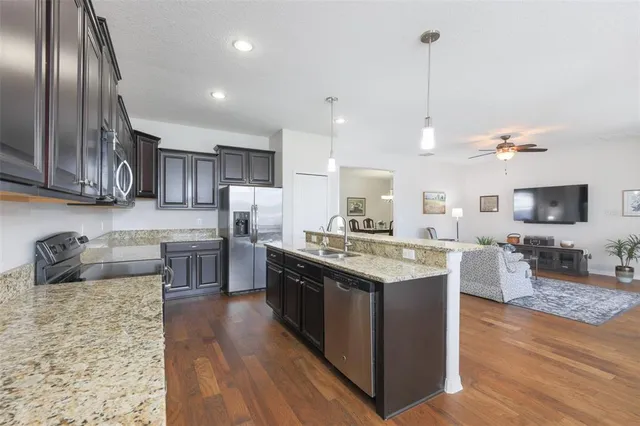 a kitchen with stainless steel appliances granite countertop a sink stove and refrigerator