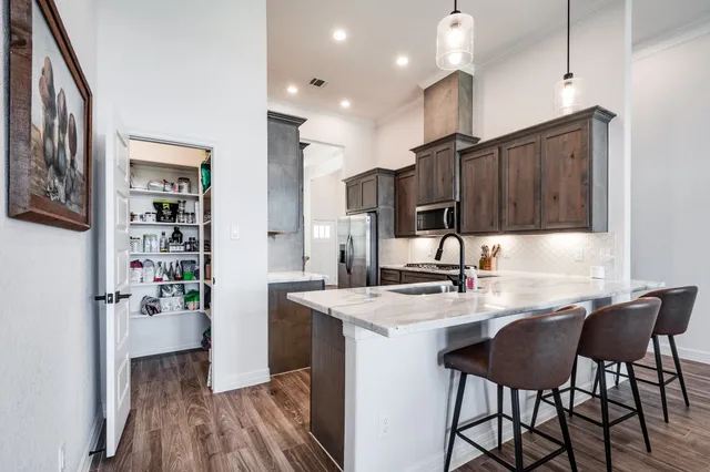a kitchen with a table chairs refrigerator and cabinets