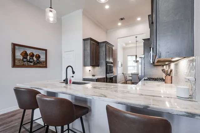 a kitchen with granite countertop a sink cabinets and dining table