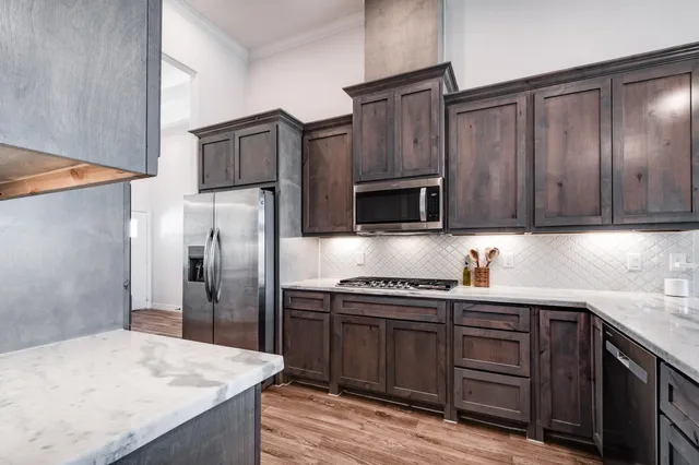 a kitchen with stainless steel appliances wooden cabinets and a sink