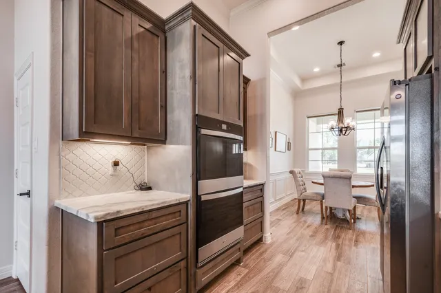 a kitchen with granite countertop a refrigerator stove and wooden floor