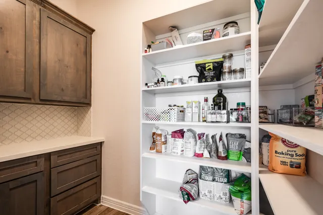 a utility room with lots of clutter and cabinets