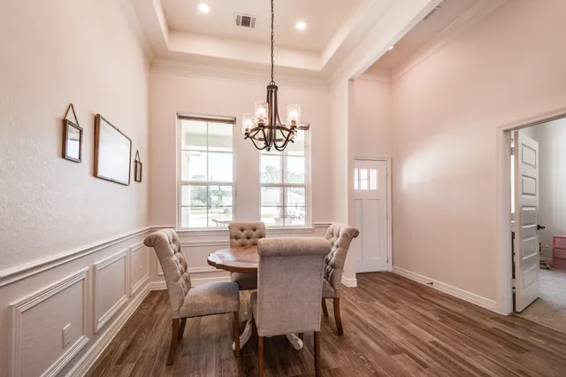 a view of a a dining room with furniture window and wooden floor