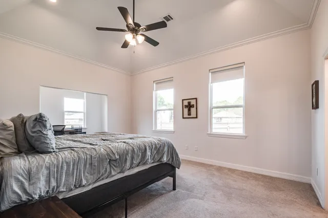 a bedroom with a bed chandelier and window