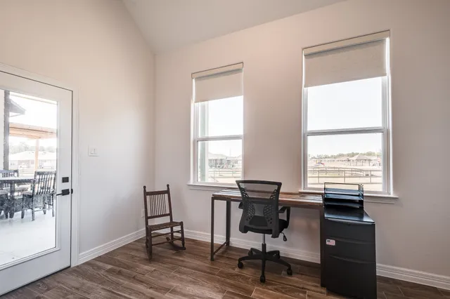 a view of a workspace with furniture and a window