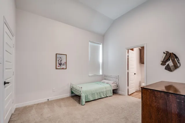 a spacious bedroom with a bed and painting on the wall