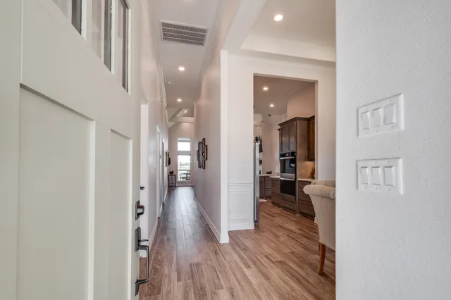 a view of a hallway with a dining table and chairs