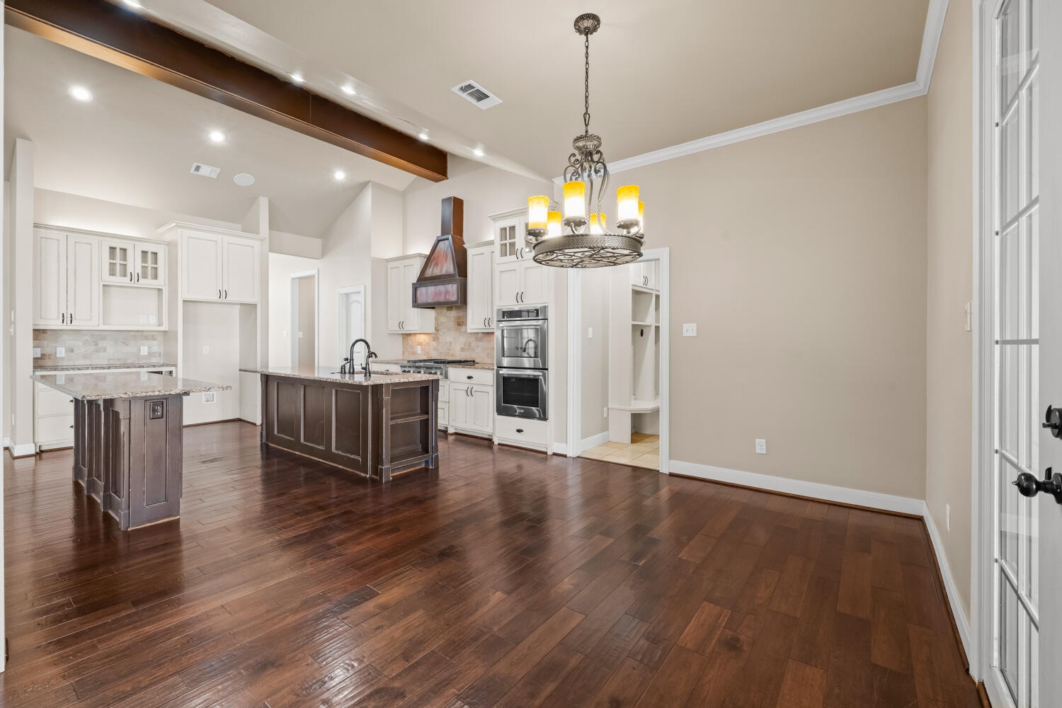 1405 11th Place Shallowater, TX 79363 - Photo 14 of 81 a view of a kitchen and dining room with wooden floor a chandelier