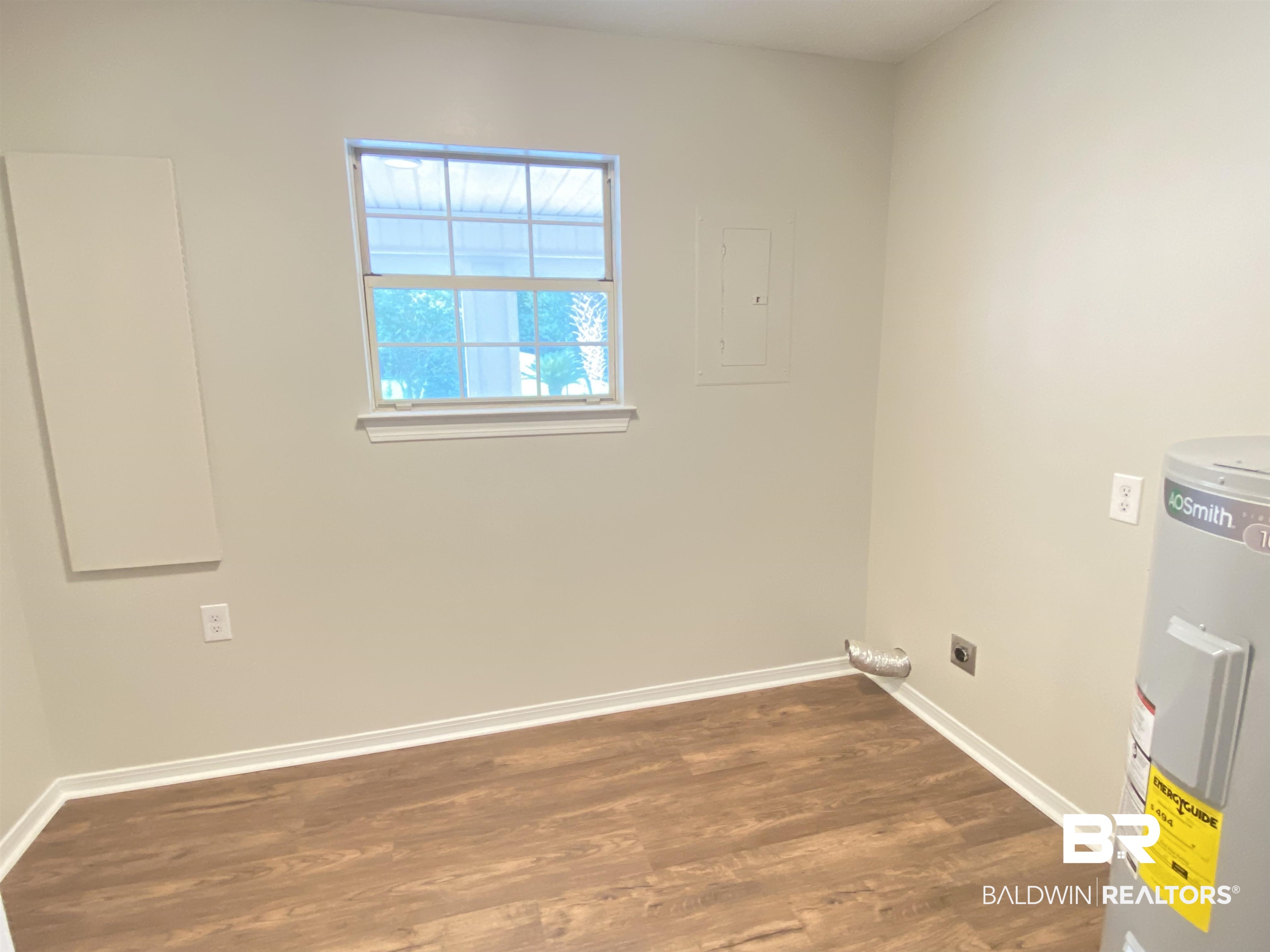 12150 Lee Bishop Road Irvington, AL 36544 - Photo 24 of 26 Unfurnished room featuring baseboards, water heater, and wood finished floors