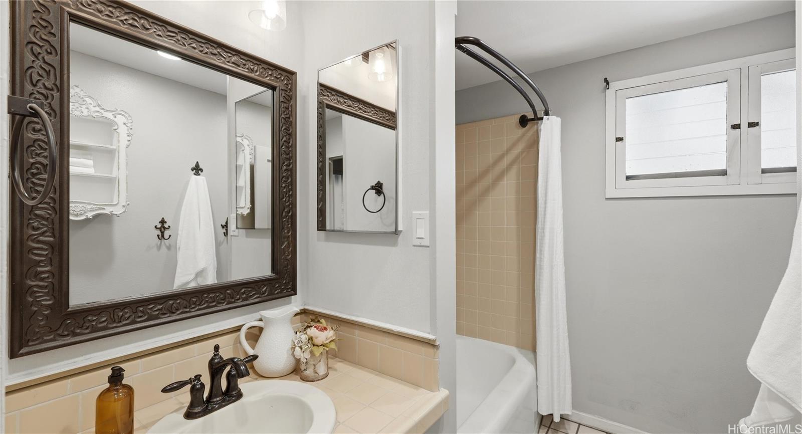 91-779 Fort Weaver Road Ewa Beach, HI 96706 - Photo 18 of 25 Full guest bathroom featuring a tiled vanity, shower/tub combo, and privacy window.