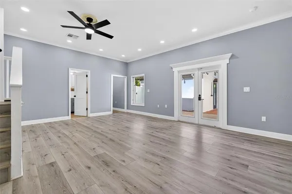 a view of a livingroom with a ceiling fan wooden floor and a ceiling fan