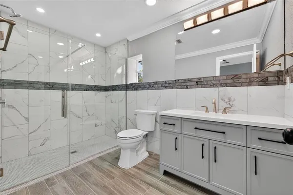 a bathroom with a sink a toilet and shower