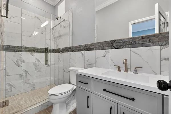 a bathroom with a sink a toilet and shower