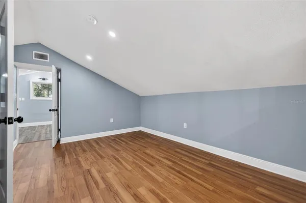 a view of an empty room with wooden floor