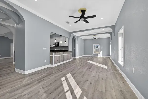 a view of a livingroom with a fireplace wooden floor and a ceiling fan